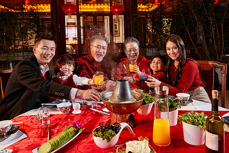 东方家庭在中式庭院内干杯庆祝新年高清图片