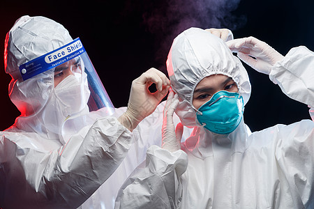 护士医药烧瓶穿防护服的青年男人帮同事调节口罩背景