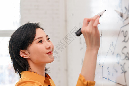 商务女士在办公室的白板上写字图片