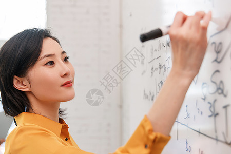 商务女士在办公室的白板上写字图片