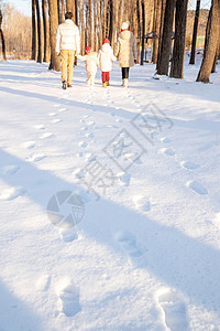 小孩背影快乐家庭在雪地里散步背景