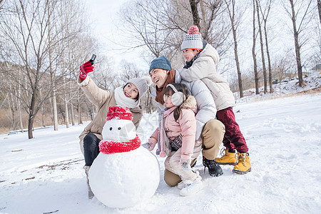 雪地玩耍欢乐家庭在雪地里堆雪人背景