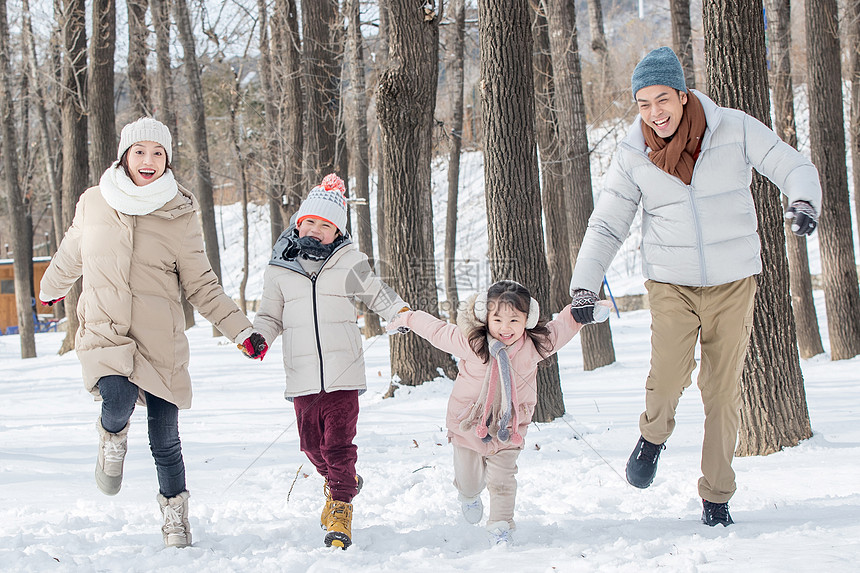 欢乐家庭在雪地里奔跑图片