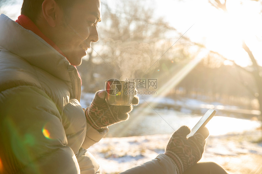 坐在雪地里看手机的男人图片