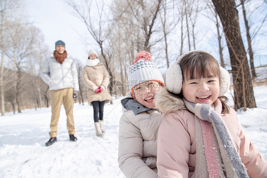 欢乐家庭在雪地上玩雪橇图片