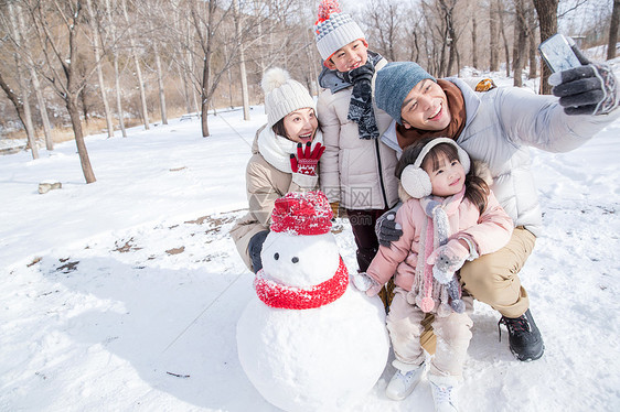 欢乐家庭在雪地里堆雪人图片