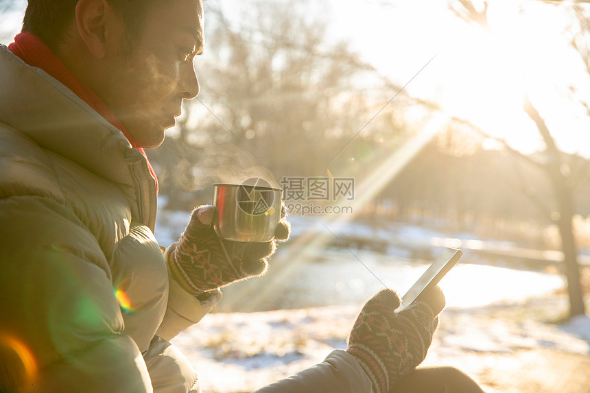 坐在雪地里看手机的男人图片