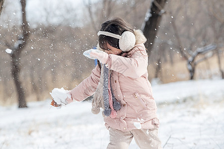 快乐的小女孩在雪地里玩耍图片