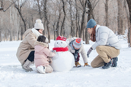 欢乐家庭在雪地里堆雪人图片