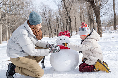 爸爸和孩子推雪人图片