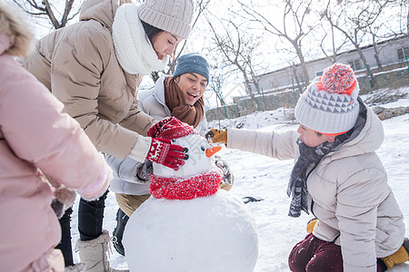 儿童手套欢乐家庭在雪地里堆雪人背景