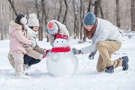 欢乐家庭在雪地里堆雪人图片