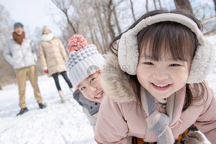 欢乐家庭在雪地上玩雪橇图片