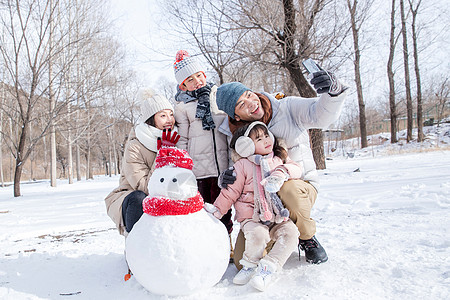 欢乐家庭在雪地里堆雪人图片