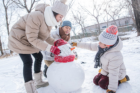 北京天坛一家三口在雪地里堆雪人背景