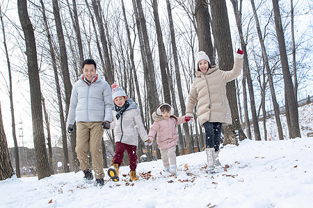 欢乐家庭在雪地里奔跑图片