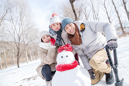 一家三口在雪地里堆雪人图片