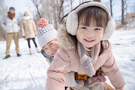 欢乐家庭在雪地上玩雪橇图片