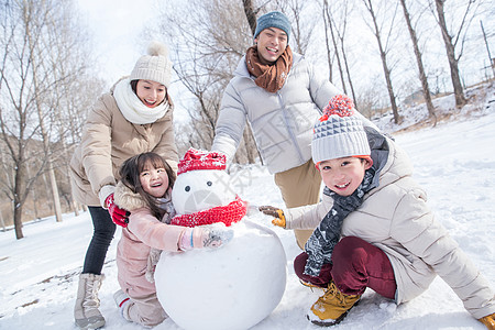 欢乐家庭在雪地里堆雪人图片