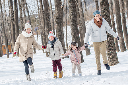 欢乐家庭在雪地里奔跑图片