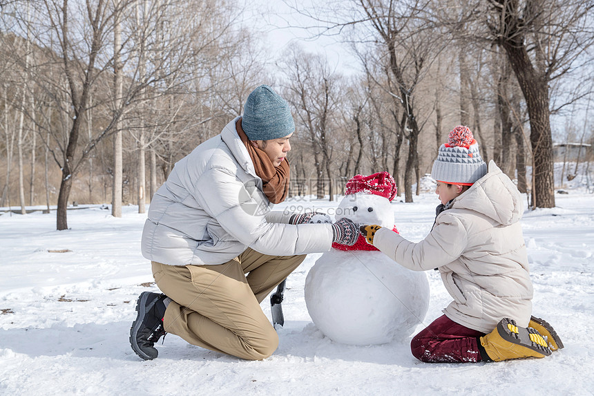 爸爸和孩子推雪人图片