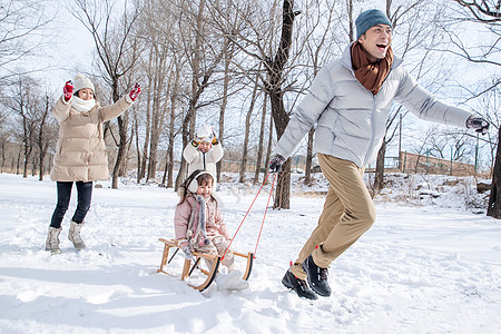 欢乐家庭在雪地上玩雪橇图片