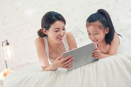 玩ipad的小孩快乐的母女俩玩平板电脑背景