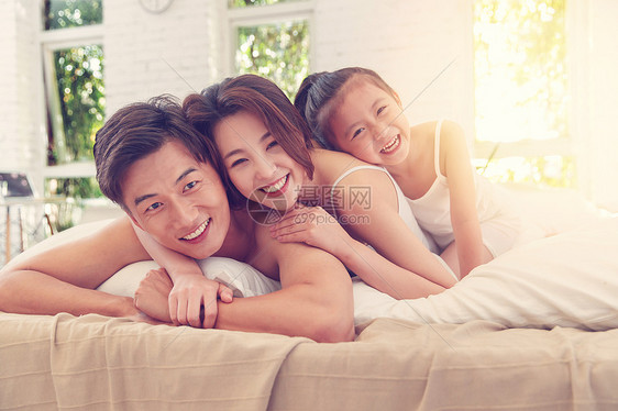 卧室床上幸福的三口之家图片