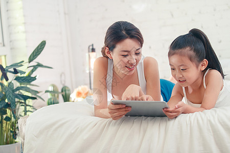小孩玩iPad快乐的母女俩玩平板电脑背景