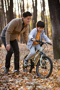 户外父亲教儿子骑自行车图片
