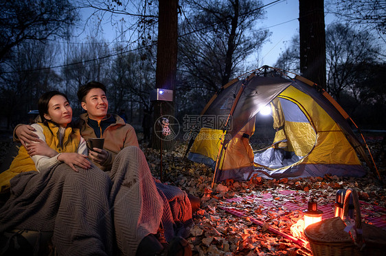 幸福的夫妇夜晚在野外露营图片