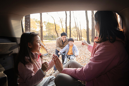 幸福母女在车中游戏快乐父子在学自行车图片