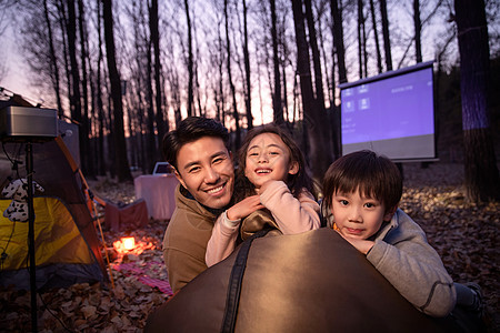 幸福的父亲和两个孩子夜晚野外露营图片