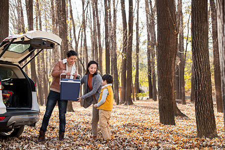 秋天幸福的三口之家在户外郊游图片