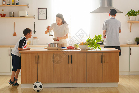 在厨房里做饭的一家三口高清图片