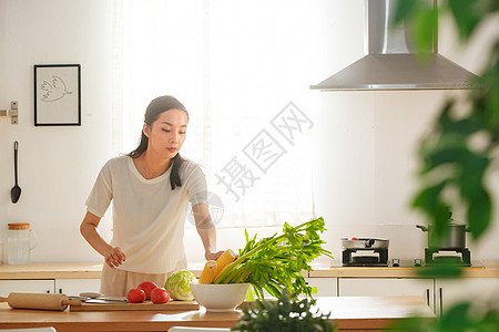 青年女人在厨房里做饭图片