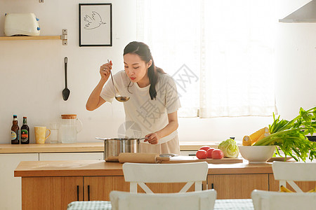 青年女人在厨房里做饭高清图片