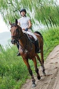 河边小路骑着马的漂亮年轻女孩图片