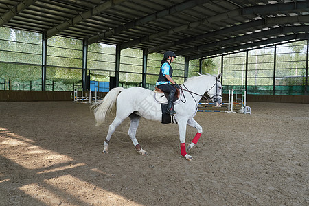 障碍训练场上骑马的青少年女孩图片