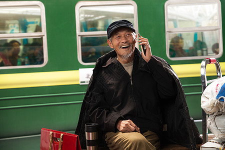 在火车站台上打电话的老人图片