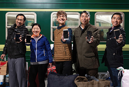 站在火车月台上展示手机的旅客图片