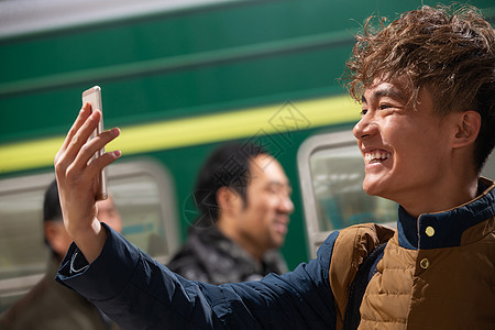 站在火车月台上打电话的旅客图片