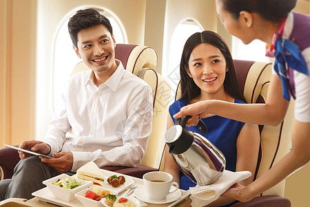 工作服餐饮年轻夫妇在飞机上用餐背景