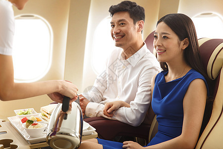 年轻夫妇在飞机上用餐图片