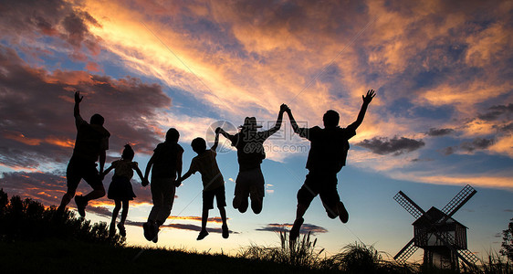 夕阳下手牵手跳跃的一家人图片