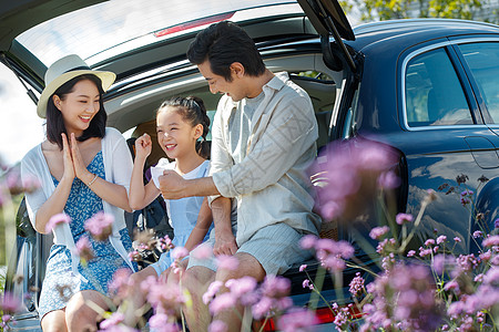 生态公园坐在汽车后备箱里玩耍的快乐家庭背景