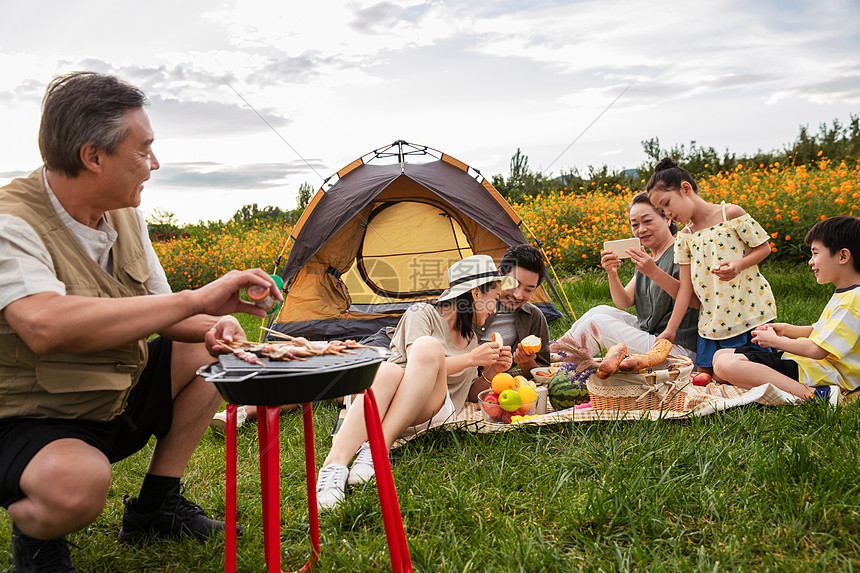 快乐家庭在郊外烧烤野餐图片