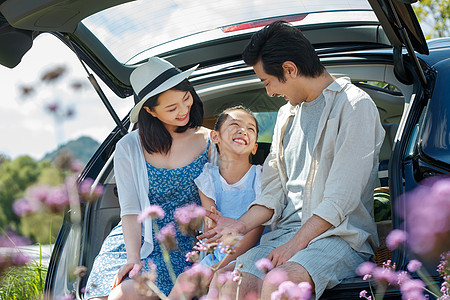 爸爸和女儿玩耍坐在汽车后备箱里玩耍的快乐家庭背景