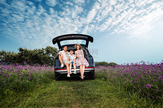 坐在汽车后备箱上的一家人图片