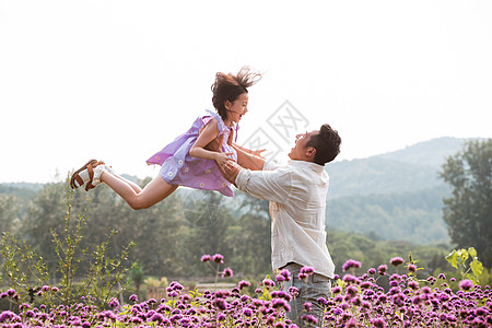父亲抱着女儿在花丛中玩耍图片